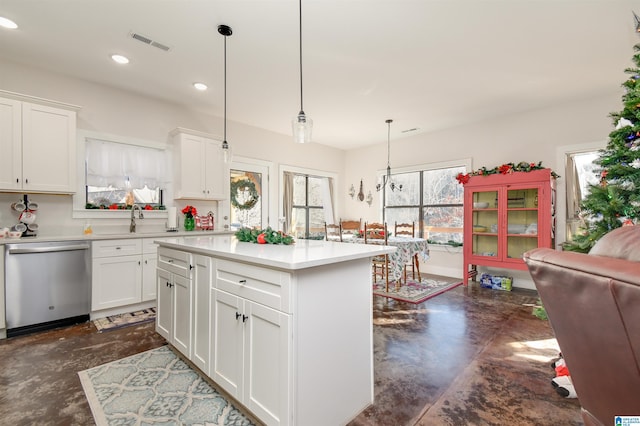 kitchen with pendant lighting, white cabinets, dishwasher, and a kitchen island