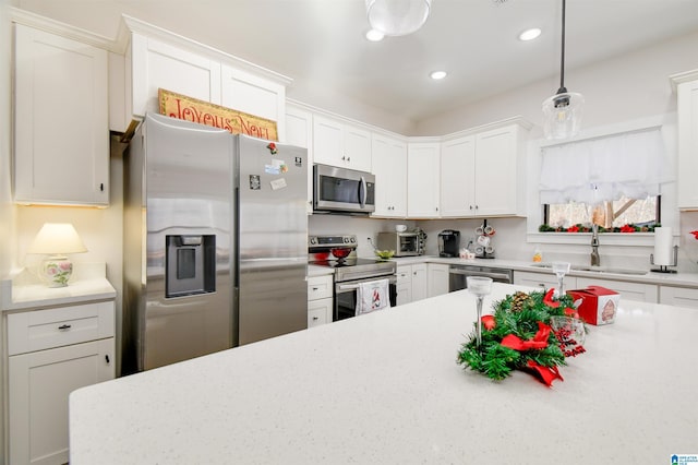 kitchen featuring sink, pendant lighting, white cabinets, and stainless steel appliances