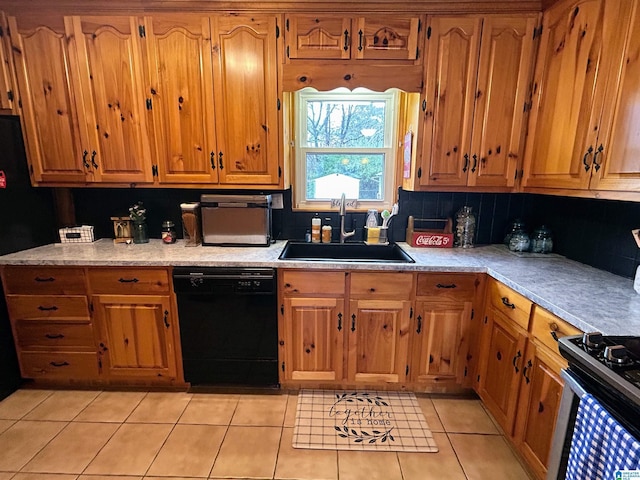 kitchen with light tile patterned flooring, black dishwasher, stainless steel range oven, and sink