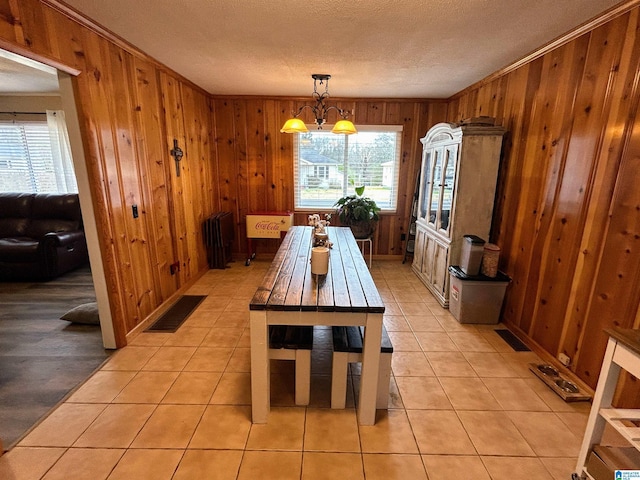 tiled dining area with a notable chandelier and wooden walls