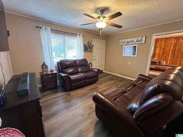 living room featuring wood-type flooring, a textured ceiling, ceiling fan, and ornamental molding