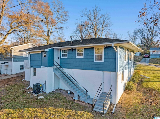 back of property featuring a lawn and central AC