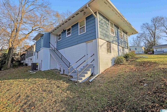 view of side of home featuring a lawn and central AC unit