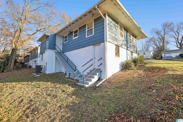 view of side of property with a yard and cooling unit