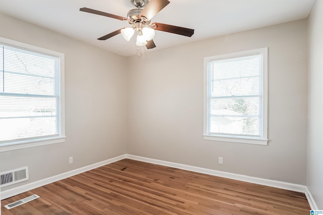 spare room featuring hardwood / wood-style floors and a healthy amount of sunlight