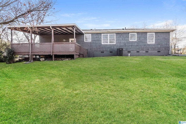 rear view of house featuring central air condition unit, a wooden deck, and a yard