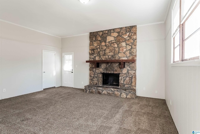 unfurnished living room featuring carpet flooring, a stone fireplace, and crown molding