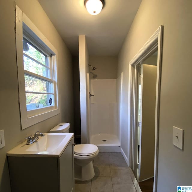 bathroom with a shower, vanity, toilet, and tile patterned flooring