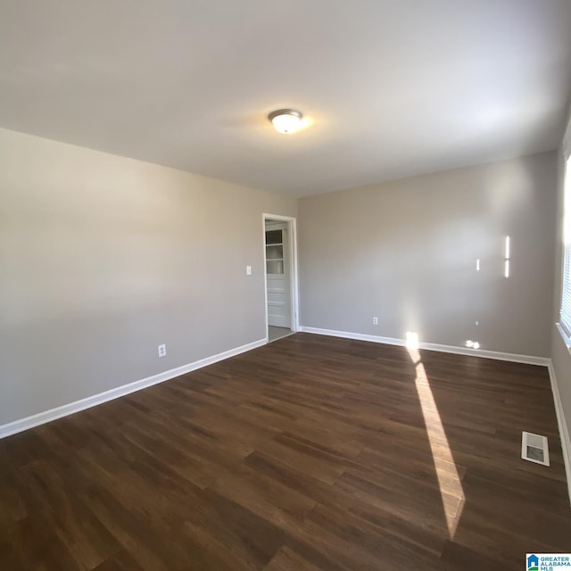 spare room featuring dark wood-type flooring