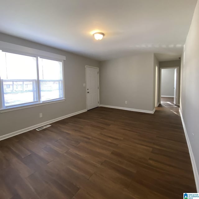 unfurnished room with dark wood-type flooring