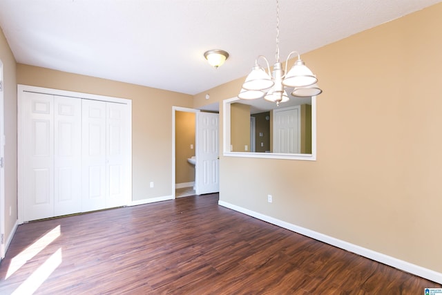 interior space featuring a notable chandelier, dark hardwood / wood-style floors, and a closet