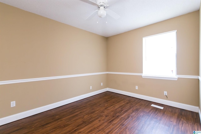 spare room featuring ceiling fan and dark hardwood / wood-style floors