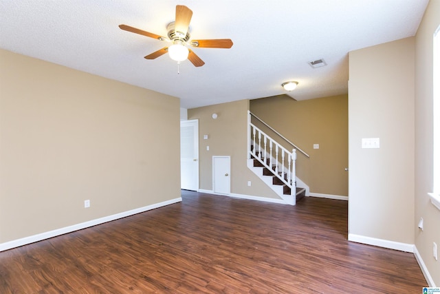 empty room with a textured ceiling, dark hardwood / wood-style flooring, and ceiling fan