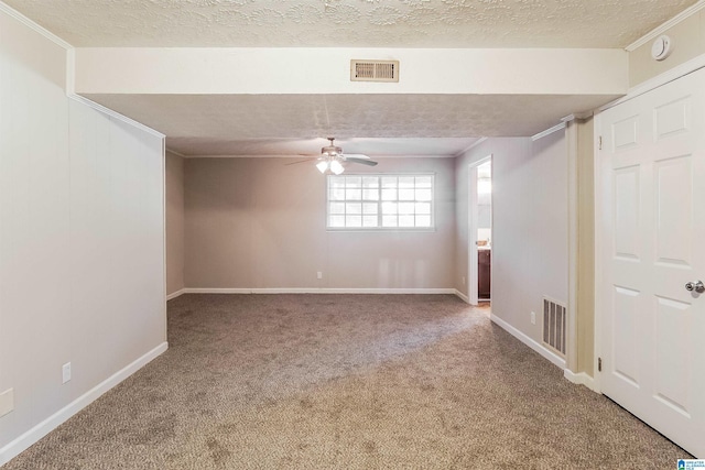 empty room with carpet flooring, ceiling fan, a textured ceiling, and ornamental molding