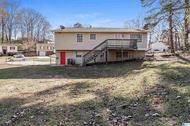 rear view of property featuring a deck, a yard, and central AC