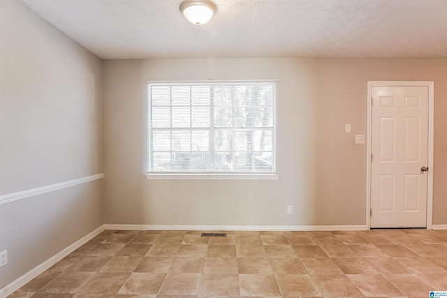 spare room with a textured ceiling