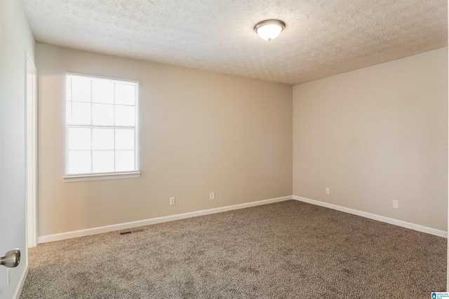 carpeted spare room with a textured ceiling