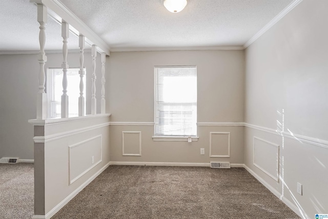 spare room featuring carpet flooring, ornamental molding, and a textured ceiling