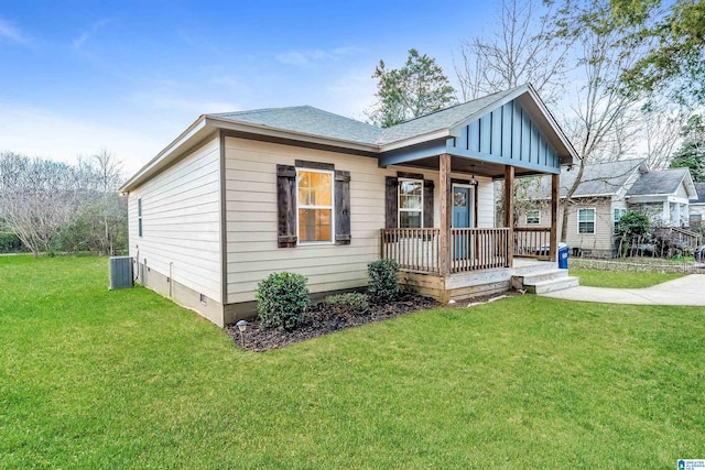 view of front of home with cooling unit, a front lawn, and covered porch