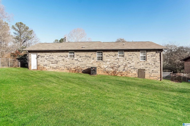 back of house featuring a lawn and central air condition unit