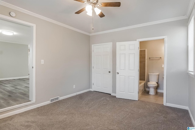 unfurnished bedroom with ensuite bath, ceiling fan, crown molding, and carpet floors