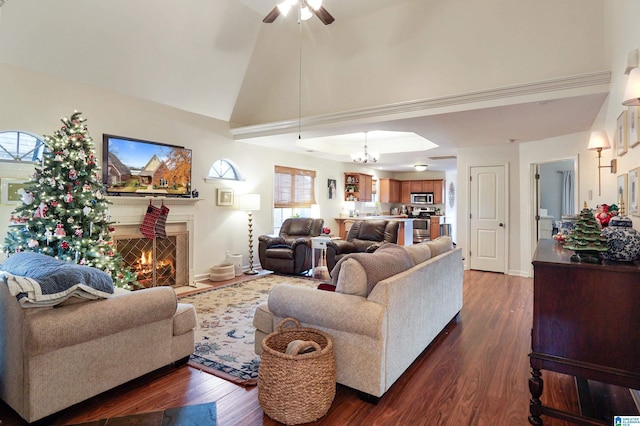 living room with vaulted ceiling, dark wood-type flooring, and ceiling fan with notable chandelier