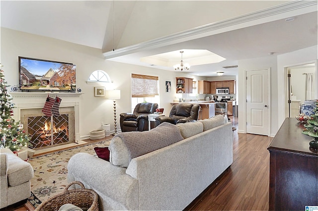 living room featuring a tray ceiling, an inviting chandelier, and dark hardwood / wood-style floors