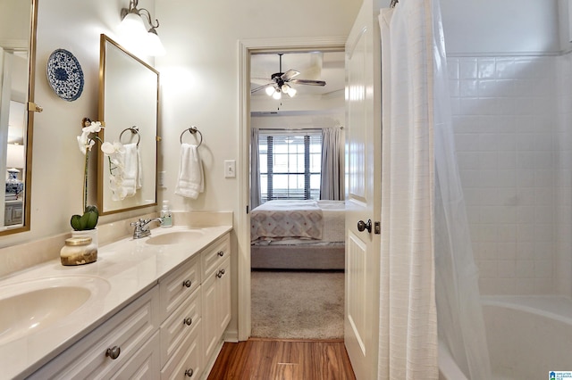 bathroom featuring ceiling fan, hardwood / wood-style floors, vanity, and shower / bath combo