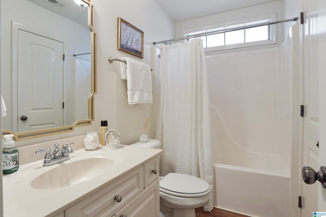 full bathroom featuring shower / bath combo, vanity, and toilet