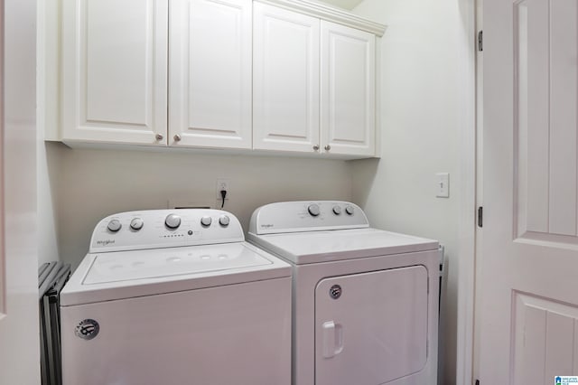 laundry area featuring washer and dryer and cabinets