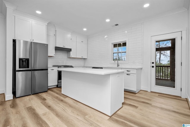 kitchen with white cabinetry, a center island, light wood-type flooring, and appliances with stainless steel finishes