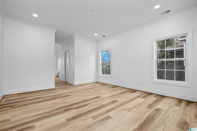 spare room with light hardwood / wood-style floors and crown molding