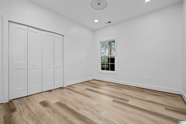 unfurnished bedroom featuring a closet and light hardwood / wood-style flooring