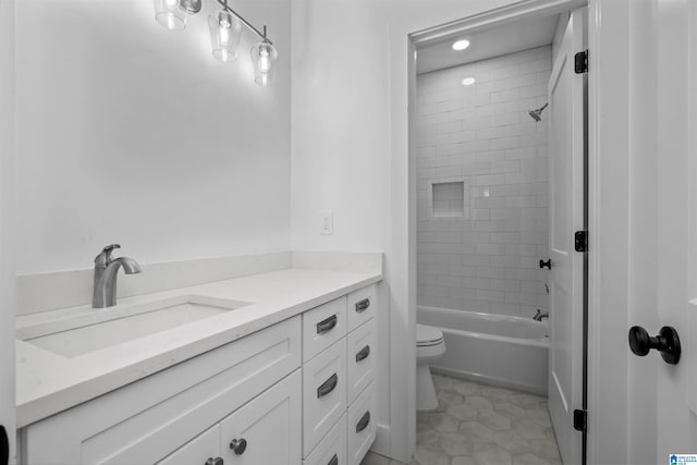 full bathroom featuring tile patterned floors, tiled shower / bath, vanity, and toilet