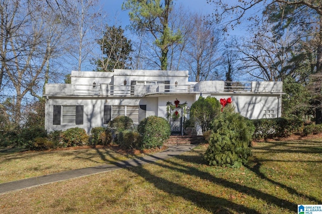 art deco home featuring a front lawn