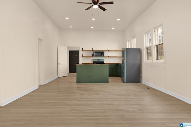 kitchen featuring a center island, stainless steel appliances, light hardwood / wood-style flooring, and ceiling fan