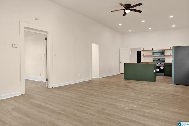 kitchen featuring ceiling fan, a center island, stainless steel appliances, and light hardwood / wood-style flooring