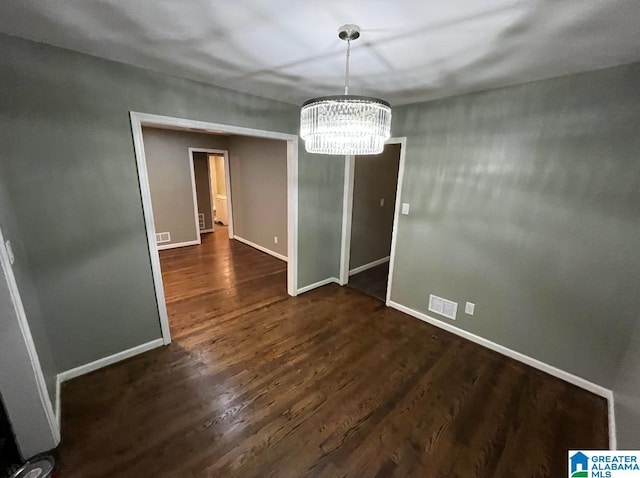 unfurnished dining area featuring dark hardwood / wood-style flooring and a chandelier