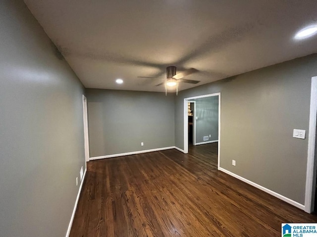 spare room with dark hardwood / wood-style flooring and ceiling fan