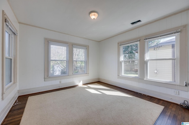 spare room with crown molding and dark hardwood / wood-style flooring