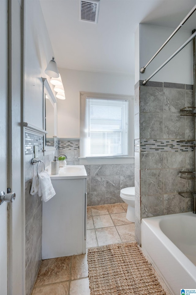 full bathroom with toilet, vanity, bathing tub / shower combination, and tile walls