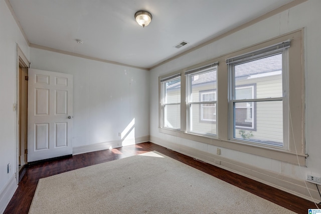 empty room featuring dark hardwood / wood-style floors and ornamental molding