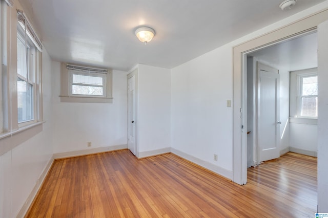 unfurnished room featuring a wealth of natural light and light wood-type flooring