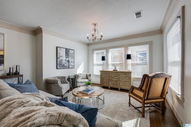 living room featuring hardwood / wood-style flooring, a notable chandelier, and crown molding