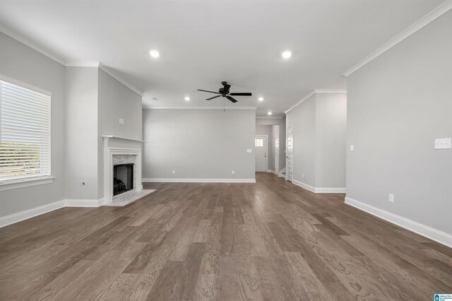 unfurnished living room featuring crown molding, hardwood / wood-style floors, a high end fireplace, and ceiling fan