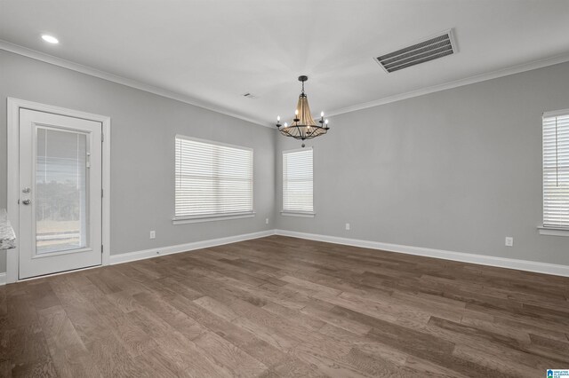 spare room with ornamental molding, wood-type flooring, and a notable chandelier