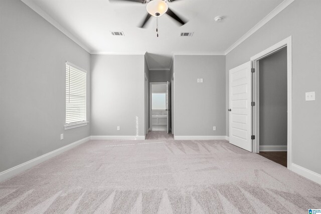 carpeted spare room with ceiling fan and ornamental molding