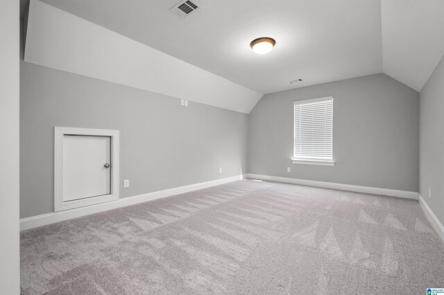 bonus room featuring light carpet and vaulted ceiling