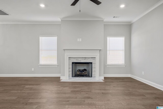 unfurnished living room with hardwood / wood-style floors, ceiling fan, crown molding, and a high end fireplace