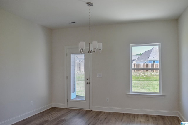 doorway to outside featuring hardwood / wood-style flooring and an inviting chandelier